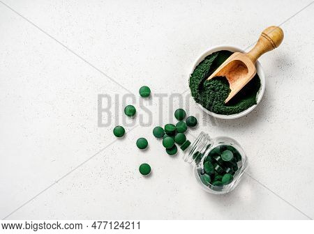 Spirulina Algae Powder And Spirulina Tablets On White Background.