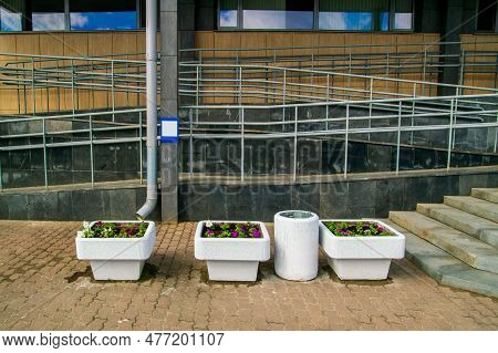 White Concrete Flower Beds And Dumpster Outside The Office Building. High Quality Photo