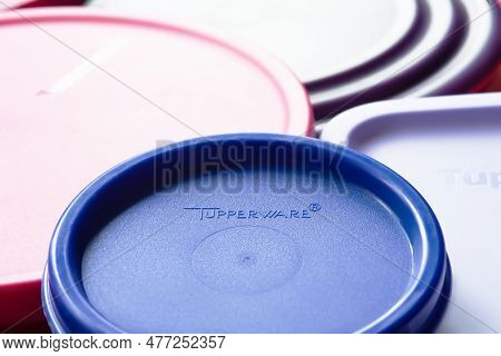 Tableware Tupperware. Lids For Dishes With The Tupperware Brand Logo In Full Frame. Textured Image W