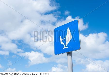 Sailboard Sign Over Blue Sky With Clouds