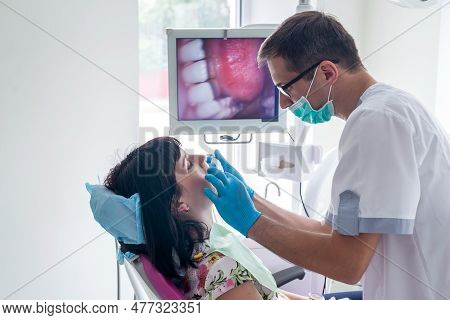 Dentist Checking Patient's Teeth With Intraoral Camera