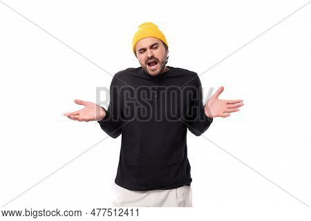 Indignant 30s Authentic Brunette Male Adult In Black Sweatshirt Shrugging Shoulders On White Backgro