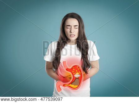 Woman Suffering From Heartburn On Turquoise Background. Stomach With Erupting Volcano Symbolizing Ac