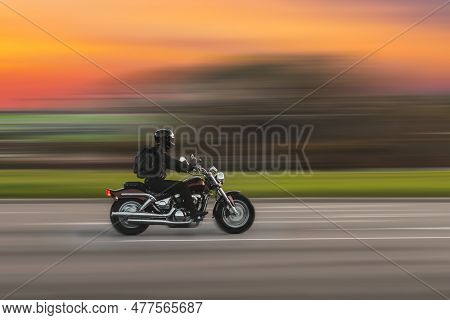 Driving Motorcycle With Speed Blurred Background. A Speeding Motorcycle On An Asphalt Street. Motion