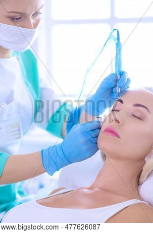 Permanent Makeup For Eyebrows. Closeup Of Beautiful Woman With Thick Brows In Beauty Salon