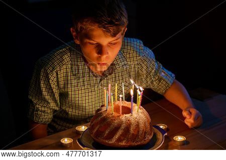 Happy Blond Little Kid Boy Celebrating His Birthday. Preteen Child Blowing Candles On Homemade Baked