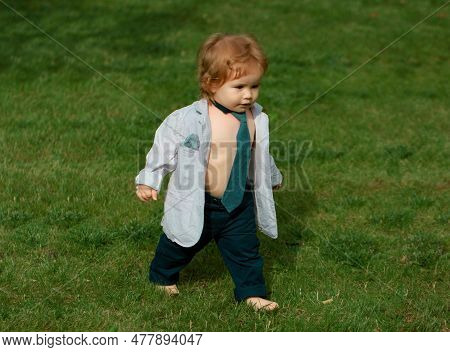 Lifestyle Portrait Baby Child In Happines At The Outside In The Meadow. Happy Baby Boy Learning To W