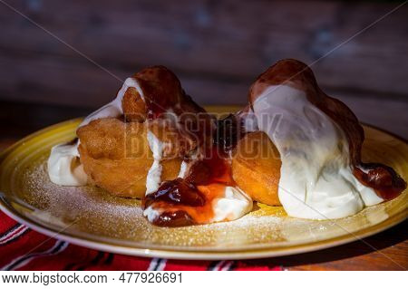 Papanasi - A Traditional Romanian Dessert. The Cake Is Made From Three Donuts Covered In Sour Cream 