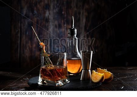 Cognac And In A Glass. Bartending Still Life With Dark Light. A Beam Of Light On A Glass.