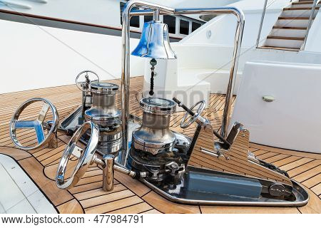 The Bow Of The Yacht With Teak Deck, With Anchor Stops, Part Of The Anchor Chain, Winch For Tighteni