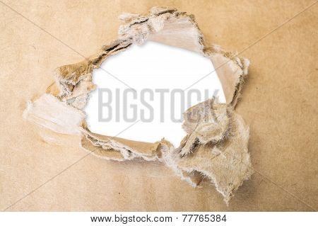 Torn hole in cardboard paper