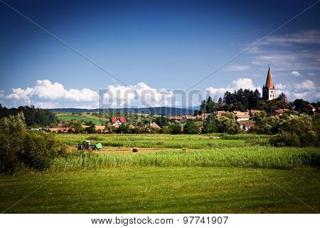 Idyllic rural view of gently rolling patchwork farmland and village