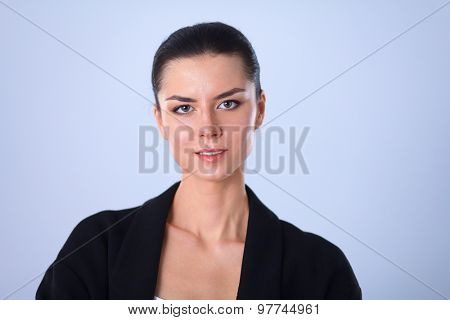 A young woman standing, isolated on graybackground