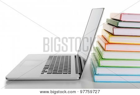 Stack of books with laptop isolated on white