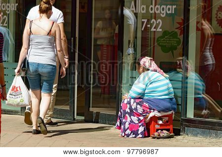 Beggar Outside A Shop