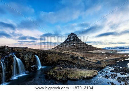 Spring Sunrise Over The Famous Kirkjufellsfoss Waterfall With Kirkjufell Mountain In The Background