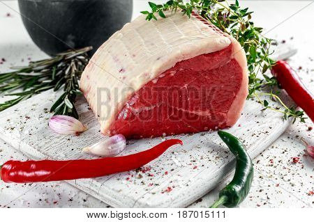 a pieces of fresh raw meat, beef slab, decorated with greens and vegetables