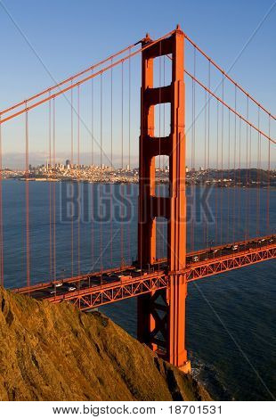 Golden Gate-bron i solnedgången med San Francisco i ryggen