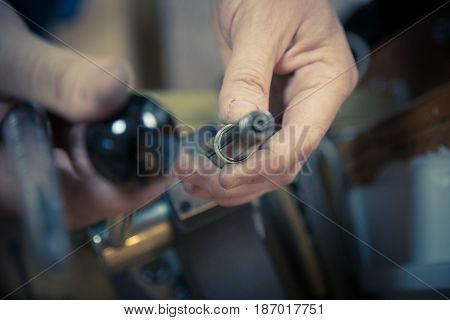 Process of wedding ring crafting. Close up of jeweler  using ring mandrel to measure the size of wedding ring