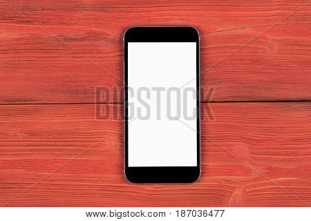 Mobile phone with blank screen mock up isolated on red wood table background. Smartphone on wood table. Smartfone white