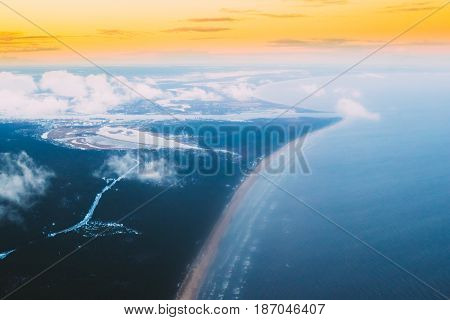 Western Dvina Flows Into The Baltic Sea. River Divides The Northern And Kurzeme District Of Riga, Latvia. View From Airplane Flight. Sunset Sunrise Over Gulf Of Riga, Bay Of Riga, Or Gulf Of Livonia
