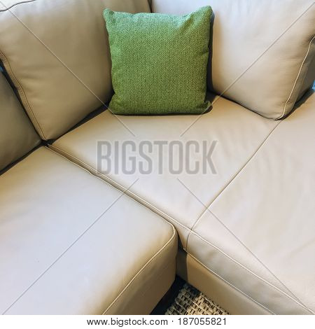 Gray corner sofa decorated with green cushion. Modern design.