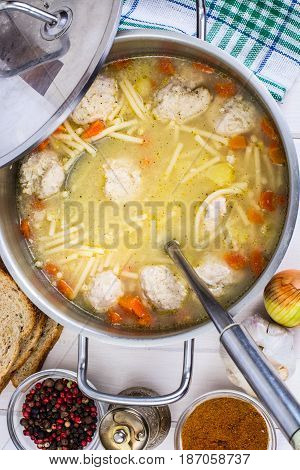 Meat broth with meatballs and spaghetti in a saucepan Studio Photo