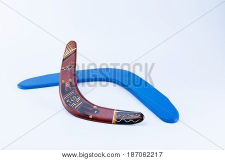 Two boomerangs a blue and a aboriginal ornamented crossing isolated on white background