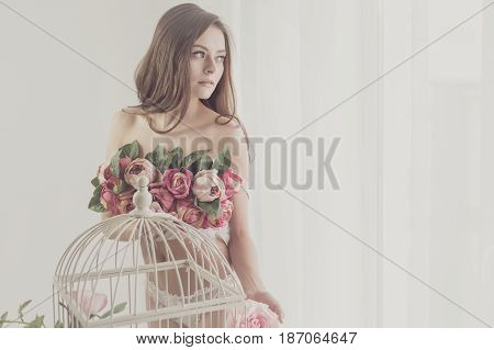 Lovely girl in underwear. Bra of flowers. Spring mood. She looks out the window. Soft focus.