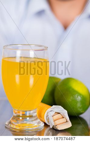 Lemon, pills of vitamin C and a glass of vitamin C dissolved over the table.