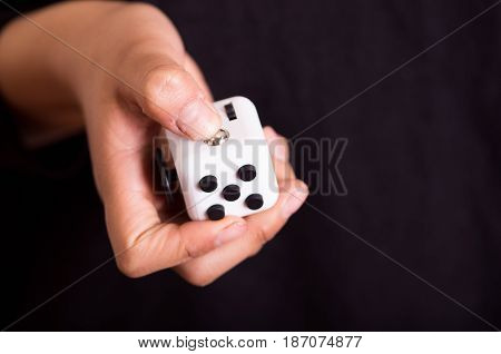 Quito, Ecuador - February 10, 2017: Man holding a Fidget Cube stress reliever, Fingers Toy.