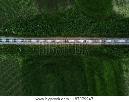 Aerial view of railway track through countryside drone top view pov of rails as abstract background