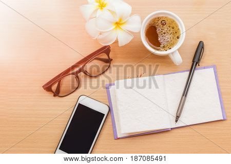 sunrise office with wooden table and laying on it with coffie