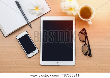 sunrise office with wooden table and laying on it with coffie