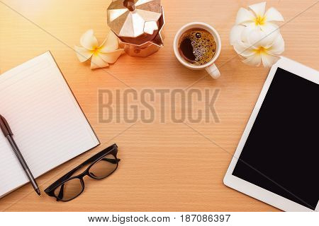 sunrise office with wooden table and laying on it with coffie