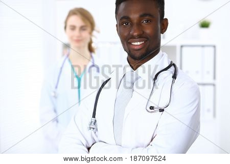 Happy african american male doctor with medical staff at the hospital.