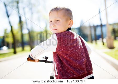 Boy riding bicycle along path in park
