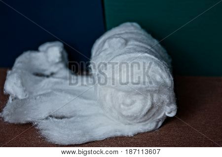 Unwound roll of white cotton on the table