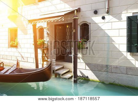 Gondola in the channel at house steps bright sunny day.