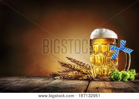 Oktoberfest beer with wheat  and hops on wooden table