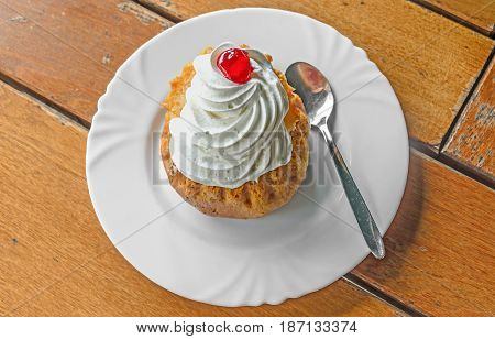 Savarin Cake With Cream And Syrup, Silver Spoon, White Plate On Wood Background