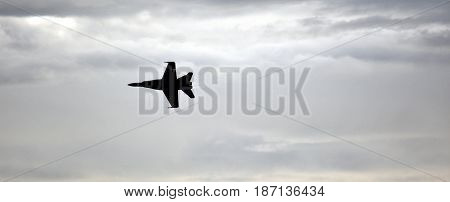Albion Park, Australia - May 6, 2017. Silhouette of F18 Hornet fighter aircraft in flight. Clouds in the background. Wings Over Illawarra is an annual air show held at Illawarra Regional Airport.