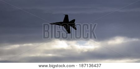 Albion Park, Australia - May 6, 2017. Silhouette of F18 Hornet fighter aircraft in flight. Clouds in the background. Wings Over Illawarra is an annual air show held at Illawarra Regional Airport.