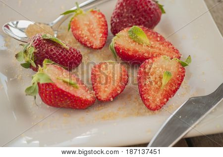 strawberries cut with sugar and mint close up