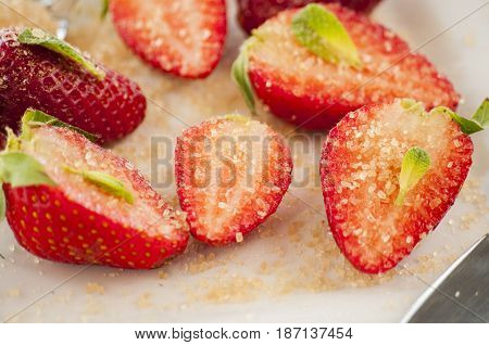 strawberries cut with sugar and mint close up