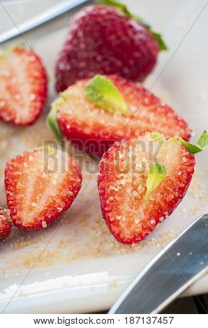 strawberries cut with sugar and mint close up