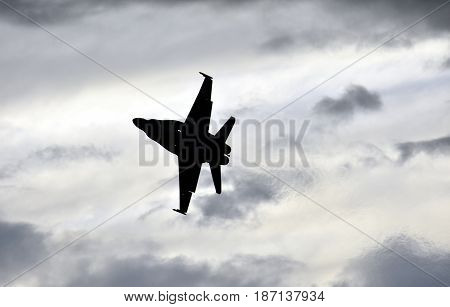 Albion Park, Australia - May 6, 2017. Silhouette of F18 Hornet fighter aircraft in flight. Clouds in the background. Wings Over Illawarra is an annual air show held at Illawarra Regional Airport.