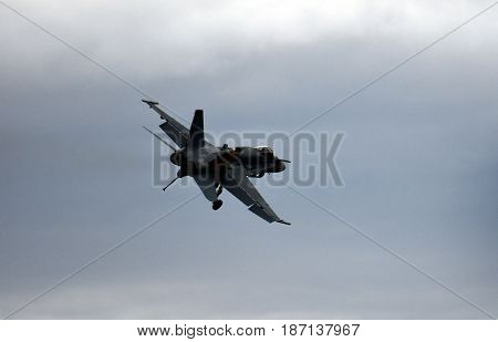 Albion Park, Australia - May 6, 2017. Silhouette of F18 Hornet fighter aircraft in flight. Clouds in the background. Wings Over Illawarra is an annual air show held at Illawarra Regional Airport.