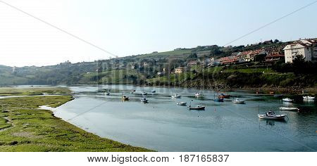 Several boats on the river with mountains background