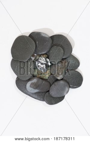 Stacked Rocks on a white background with color rocks on top